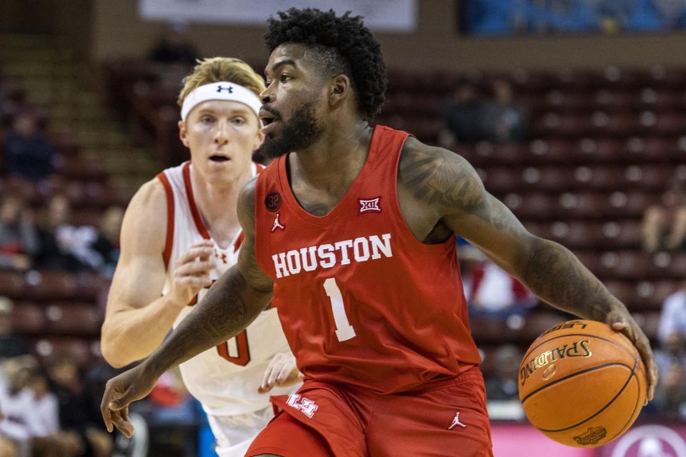 Houston’s Jamal Shead (1) dribbles against the defense of Utah’s Hunter Erickson, left, in the second half of an NCAA college basketball game during the Charleston Classic in Charleston, S.C., Friday, Nov. 17, 2023. | Mic Smith, Associated Press