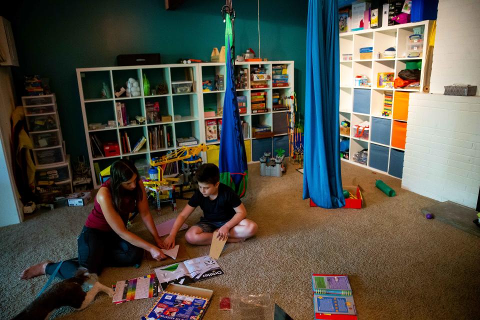 Cassie and Kai Atallah work to construct paper airplanes during a homeschool lesson at their home in Holland. Kai, who was diagnosed with autism, has been homeschooled for more than two years after experiencing the negative effects of restraint and seclusion while in school.