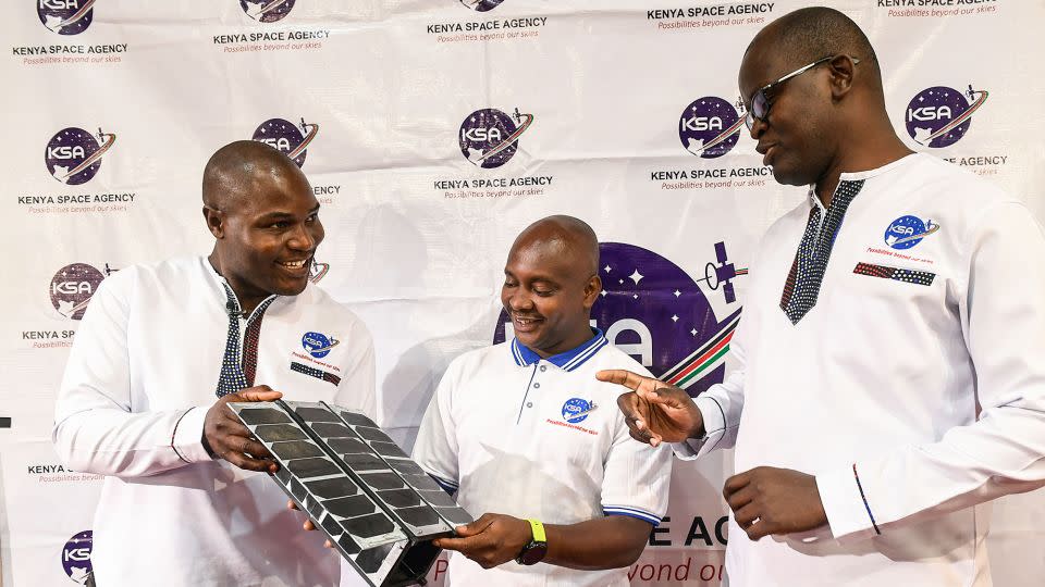 Kenya launched its first Earth observation satellite, Taifa-1, into space in April 2023. It was developed and designed by Kenyans but manufactured in Bulgaria. Here, Kenya Space Agency (KSA) engineers Aloyce Were (L), Deche Bungule (C) and Andrew Nyawade hold a prototype of the Taifa-1 satellite at the University of Nairobi in April 2023. - Simon Maina/AFP/Getty Images