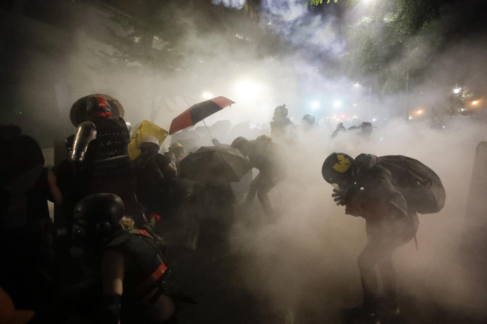 FILE - Federal officers launch tear gas at a group of demonstrators during a Black Lives Matter protest in Portland, Ore., on July 26, 2020. Residents of Portland, Oregon, will vote on a ballot measure next week that would completely overhaul the way City Hall works, amid growing voter frustration over surging homelessness and crime. It would scrap the city's unusual commission form of government and implement a rare form of ranked choice voting not used in any other U.S. city. (AP Photo/Marcio Jose Sanchez, File)