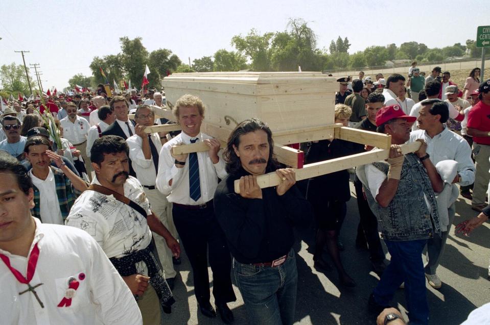 People carrying a pine casket in a procession