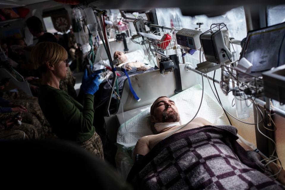 One of the wounded Ukrainian soldiers get treatment at the Hospitallers evacuation bus as they are being transported from Donetsk Oblast to a hospital in Dnipro city on April 25, 2024. (Serhii Korovayny/The Kyiv Independent)