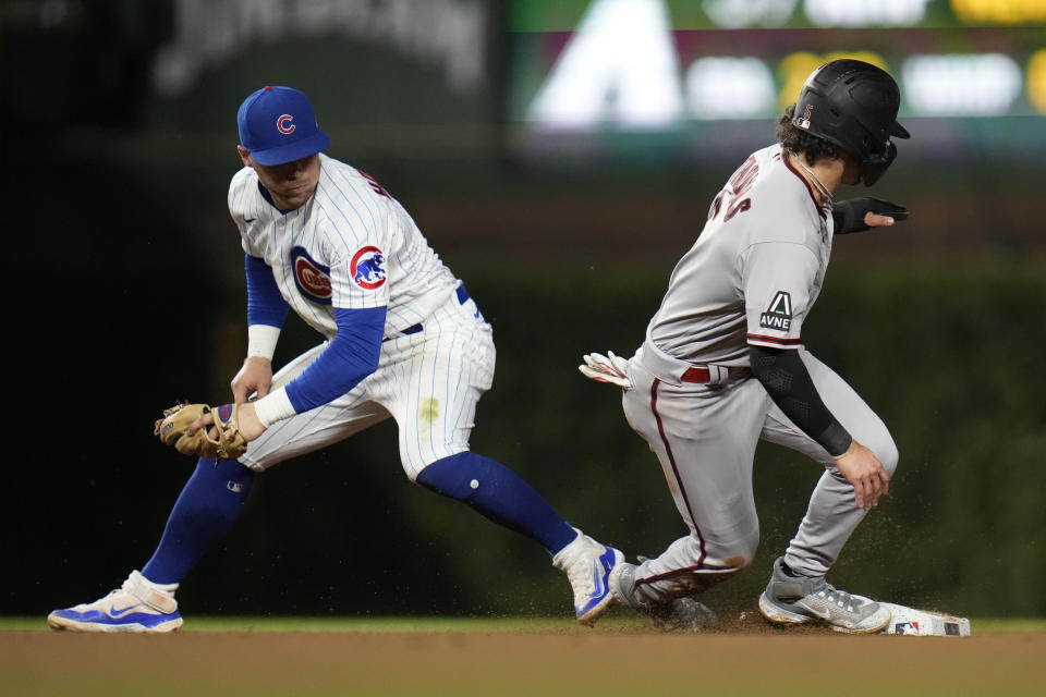 Chicago Cubs second baseman Nico Hoerner, left, looks over as Arizona Diamondbacks' Alek Thomas steals second during the eighth inning of a baseball game Thursday, Sept. 7, 2023, in Chicago. (AP Photo/Erin Hooley)