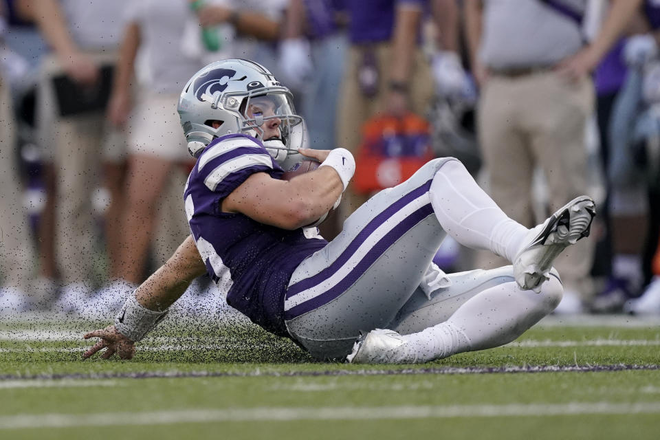 FILE - Kansas State quarterback Will Howard slides after running the ball during the first half of the team's NCAA college football game against Southern Illinois, Sept. 11, 2021, in Manhattan, Kan. Some studies — including one using NCAA injury surveillance data from 2004-14 — have concluded playing football on artificial surfaces increases the frequency of certain lower body injuries. (AP Photo/Charlie Riedel, File)