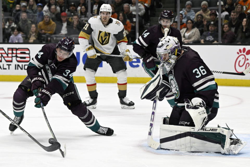 Anaheim Ducks defenseman Pavel Mintyukov (34) stops a shot with goaltender John Gibson (36) against the Vegas Golden Knights during the first period of an NHL hockey game in Anaheim, Calif., Wednesday, Dec. 27, 2023. (AP Photo/Alex Gallardo)