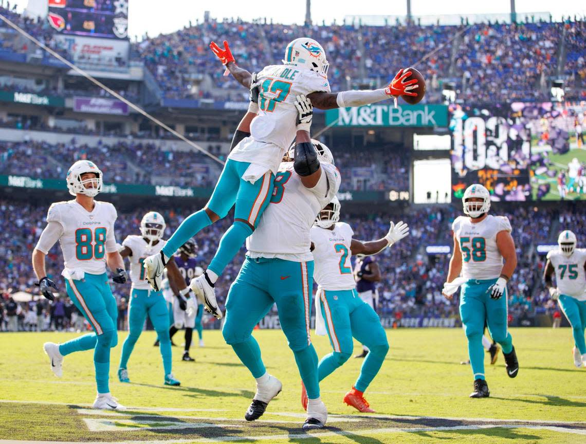 Miami Dolphins wide receiver Jaylen Waddle (17) celebrates with teammates Robert Hunt (68) Mike Gesicki (88) Chase Edmonds (2) and Connor Williams (58) after scoring the go ahead touchdown during fourth quarter of an NFL football game against the Baltimore Ravens at M&T Bank Stadium on Sunday, September 18, 2022 in Baltimore, MD.