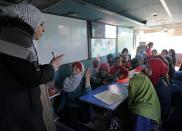Sudents attend a class inside a bus in the city of al-Bab