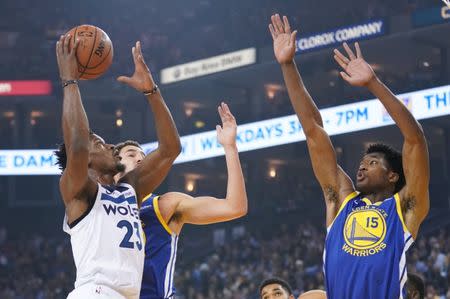 FILE PHOTO - November 2, 2018; Oakland, CA, USA; Minnesota Timberwolves guard Jimmy Butler (23) shoots the basketball against Golden State Warriors guard Klay Thompson (11) and center Damian Jones (15) during the first quarter at Oracle Arena. Mandatory Credit: Kyle Terada-USA TODAY Sports