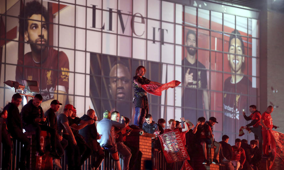 Liverpool fans celebrate outside Anfield stadium after the English Premier soccer match between Liverpool and Chelsea, Wednesday, July 22, 2020, in Liverpool, England. (Martin Rickett/PA via AP)