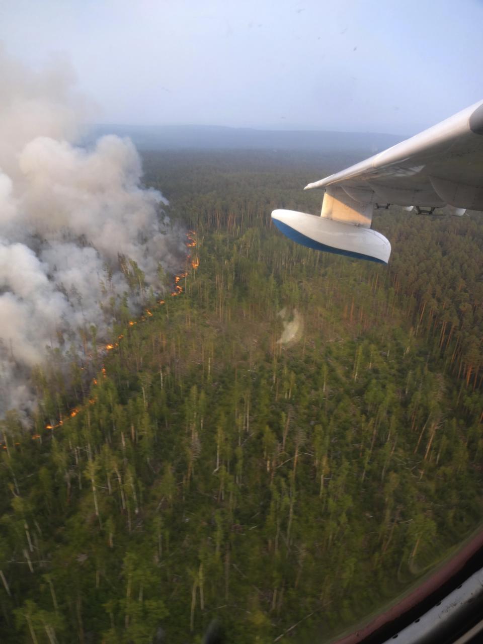 This photo taken on Tuesday, July 30, 2019 and provided by Russian Federal Agency of Forestry, shows a view of a forest fire from a window of an Emergencies Ministry's Beriev Be-200 amphibian multirole jet as its prepares to spews some tons of water onto a forest fire in the Boguchansky district of the Krasnoyarsk region, Russia Far East. Russian President Vladimir Putin has ordered Russia's military to join efforts to fight forest fires that have engulfed nearly 30,000 square kilometers (11,580 sq. miles) of territory in Siberia and the Russian Far East. (Russian Federal Agency of Forestry via AP)