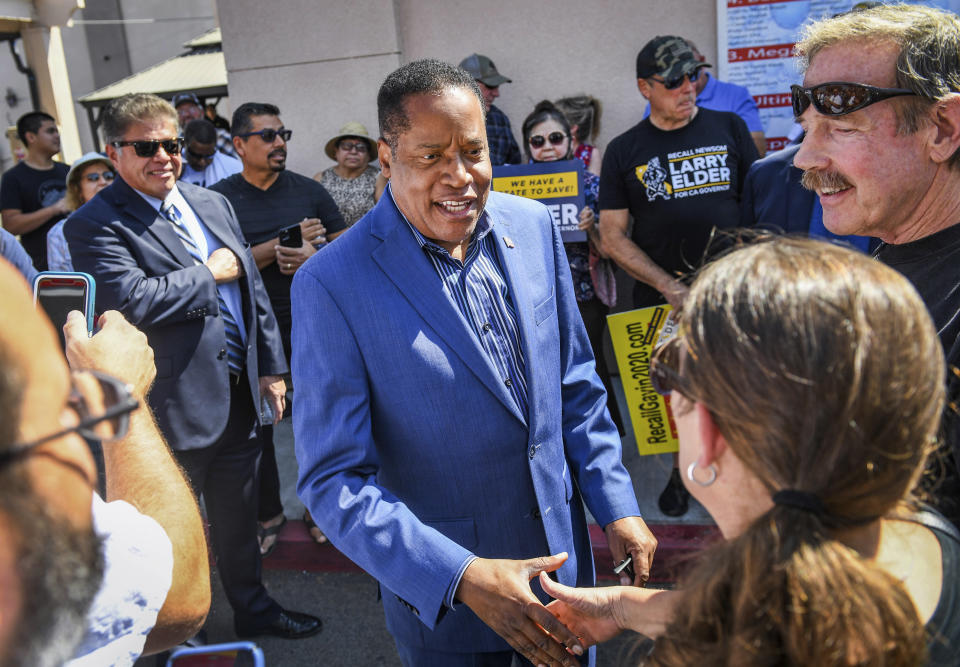 FILE — In this Sept. 7, 2021, file photo, Republican gubernatorial recall candidate Larry Elder, center, greets supporters before giving a speech in Clovis, Calif., in Fresno County. In the recall election, Gov. Gavin Newsom won big in coastal urban areas such as Los Angeles County, while the pro-recall effort performed better in the Central Valley and Northern California. Elder was the preferred replacement choice for voters who wanted Newsom removed from office. (Craig Kohlruss/The Fresno Bee via AP, File)