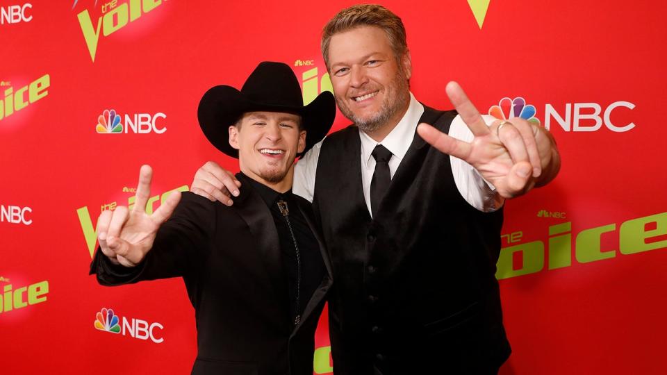 Bryce Leatherwood, wearing a black cowboy hat, poses with trainer Blake Shelton in a black vest, tie and white shirt. "Voice" carpet