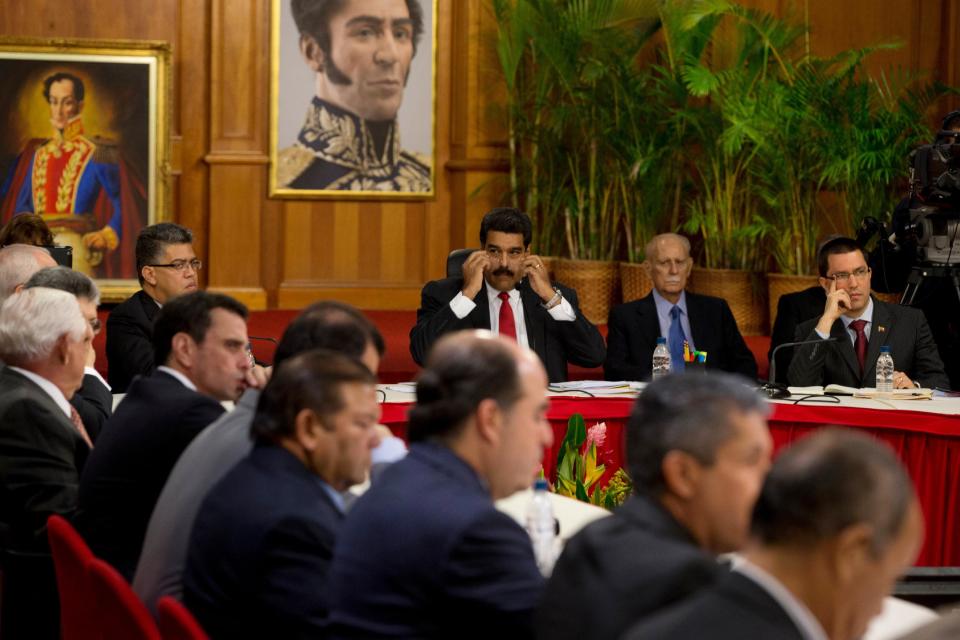 Venezuela's President Nicolas Maduro, top center, looks toward leaders of the opposition at the start of a meeting at Miraflores presidential palace in Caracas, Venezuela, Thursday, April 10, 2014. The Vatican is sponsoring the first talks aimed at reconciliation since protests began in early February. Maduro's opponents blame his government for destroying the oil-rich economy and stamping out dissent, while Maduro claims he's the target of U.S.-backed coup attempt. (AP Photo/Fernando Llano)