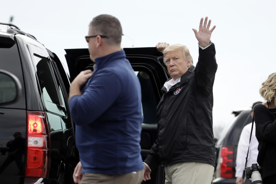 President Donald Trump waves as he boards his motorcade on arrival, Friday, March 8, 2019, in Auburn, Ala., en route to Lee County, Ala., where tornados killed 23 people. (AP Photo/Carolyn Kaster)