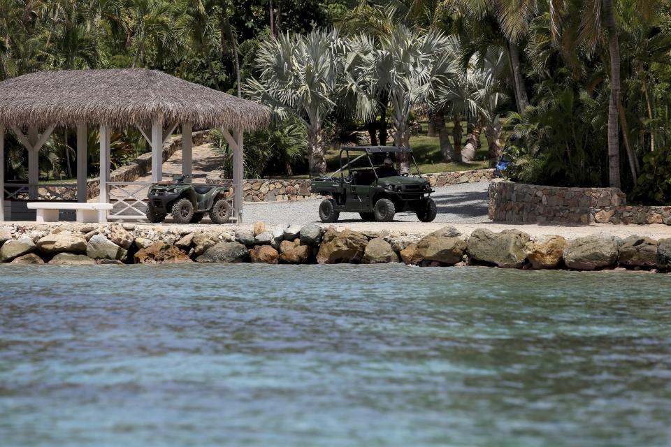 A man drives a utility task vehicle on Little St. James Island, in the U. S. Virgin Islands, a property owned by Jeffrey Epstein, Wednesday, Aug. 14, 2019. Only a handful of Epstein’s employees were seen kicking up dust as they drove around in UTV's on an island that once boasted dozens of workers and several armed security guards. (AP Photo/Gabriel Lopez Albarran)