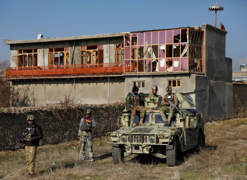 Afghan security forces inspect the site of an attack in a U.S. military air base in Bagram