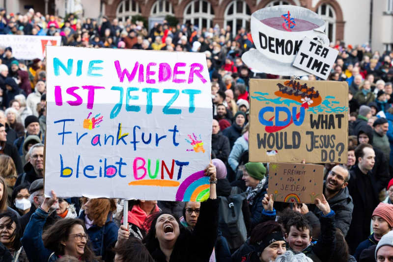 People attend a protest called "Frankfurt stands up for democracy" rally against far right extremism. "Never again is now Frankfurt remains colorful" is written on one of the signs, and "CDU what would Jesus do?" on another. Lando Hass/dpa