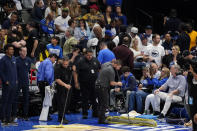 American Airlines Center employees mop up rain that was leaking from the roof during the second half of Game 4 of the NBA basketball playoffs Western Conference finals between the Dallas Mavericks and the Golden State Warriors, Tuesday, May 24, 2022, in Dallas. (AP Photo/Tony Gutierrez)