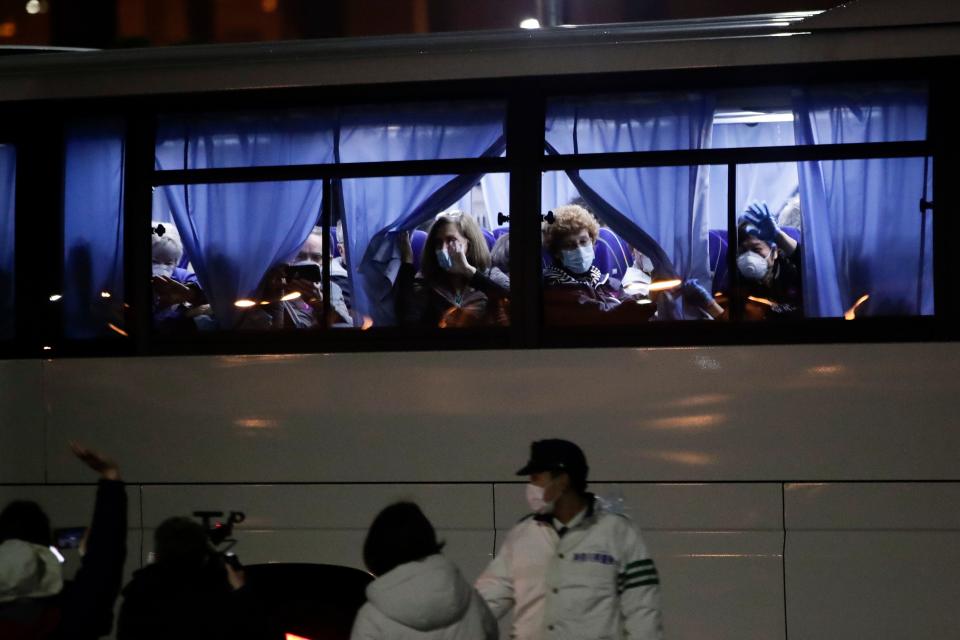 Buses carrying American passengers from the quarantined Diamond Princess cruise ship leave a port in Yokohama, near Tokyo, on Monday. (ASSOCIATED PRESS)