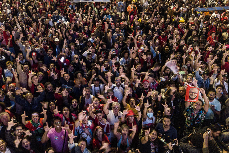 Simpatizantes del expresidente de Brasil Luiz Inácio Lula da Silva, quien se postuló de nuevo a la presidencia, escuchan los resultados parciales después de que cerraron los centros de votación para la elección general del domingo 2 de octubre de 2022 en Río de Janeiro. (AP Photo/Matias Delacroix)