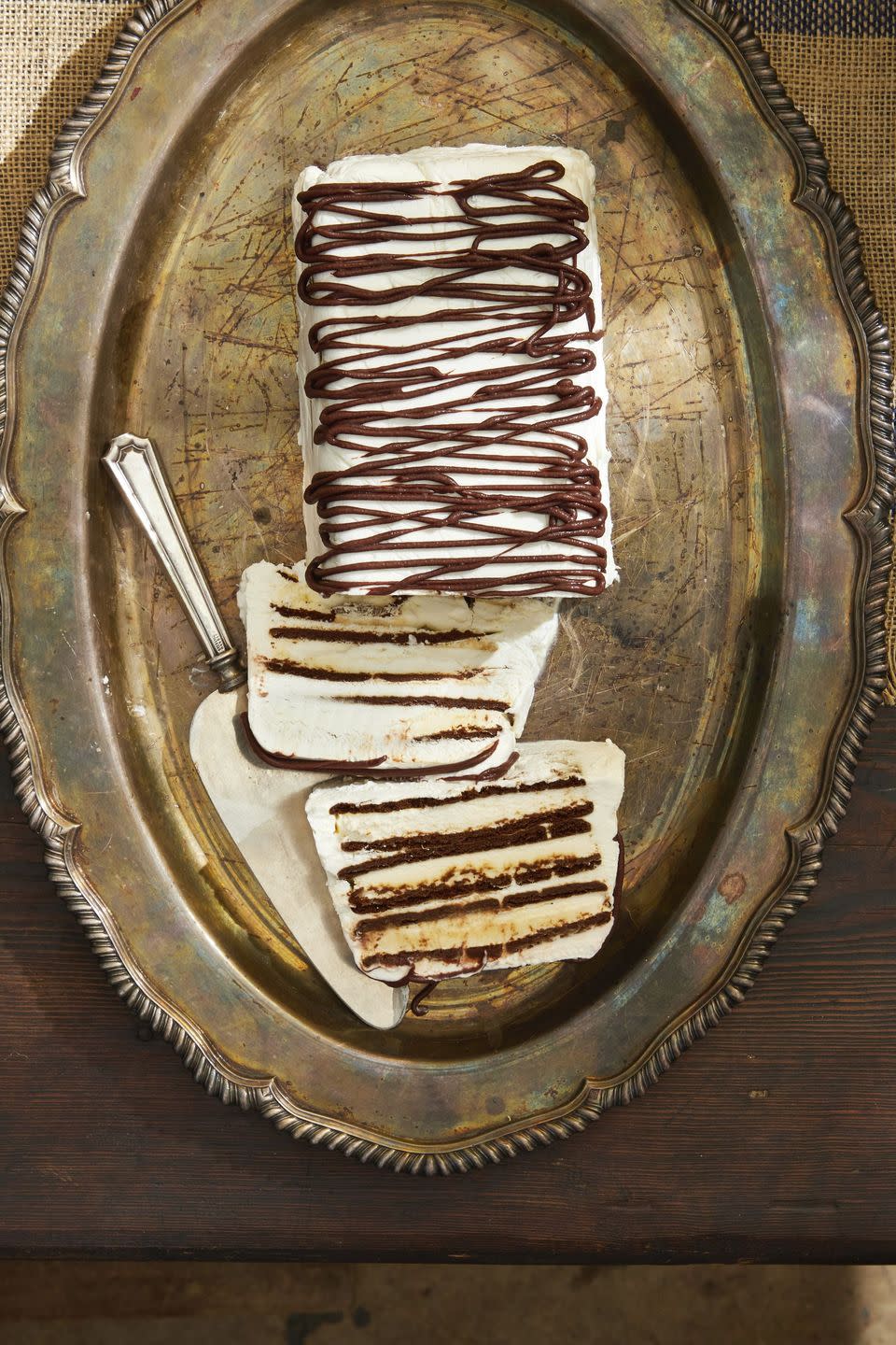 zebra semifreddo on a tarnished metal serving tray with two slices cut to show the layers inside