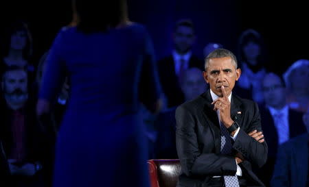 U.S. President Barack Obama listens to remarks from Taya Kyle, widow of US Navy SEAL Chris Kyle, as he participates in a live town hall event on reducing gun violence hosted by CNN’s Anderson Cooper at George Mason University in Fairfax, Virginia January 7, 2016. REUTERS/Kevin Lamarque