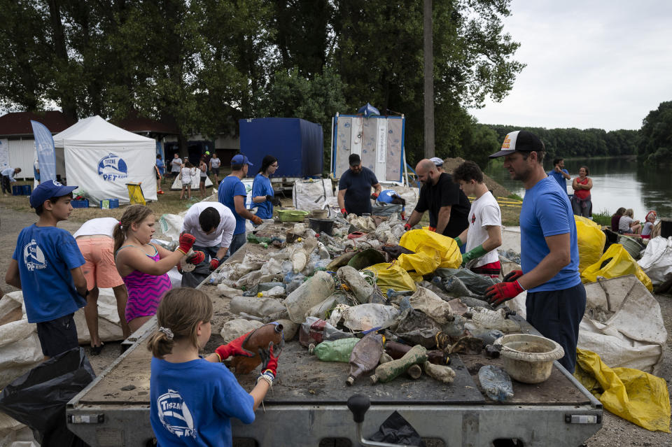 Volunteers selectively sort the collected rubbish after they arrived to the campsite for that day on Tuesday, Aug. 1, 2023. The annual Plastic Cup competition has gathered around 330 tons of waste from the Tisza since 2013. Their aim is to preserve Hungary's natural environment, but also to head off a mounting global plastic waste crisis by cutting it off early in the cycle. (AP Photo/Denes Erdos)