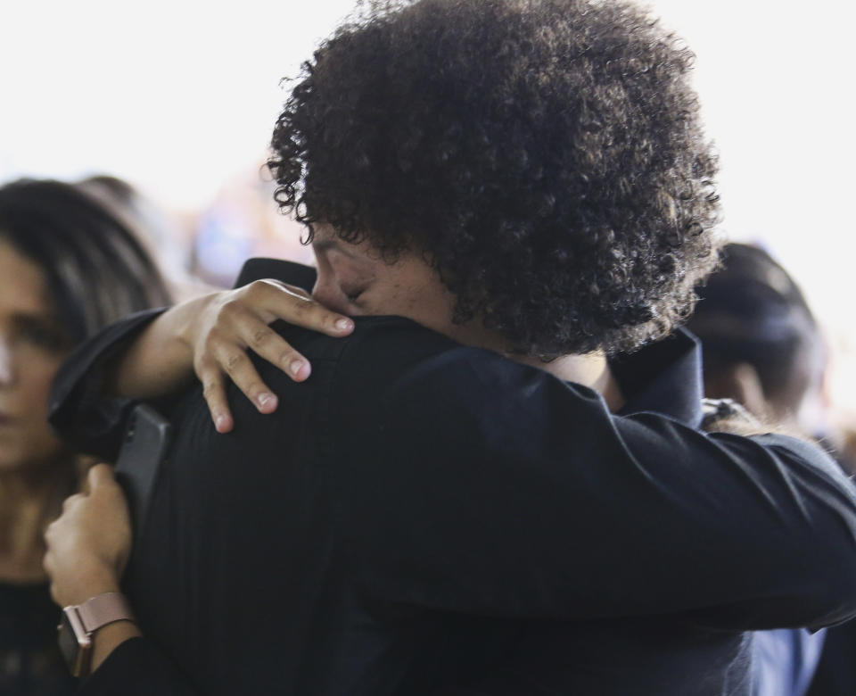 Family and friends hug during a memorial for Christopher Morgan at West Orange High School in West Orange, N.J., Tuesday, June 11, 2019. West Point officials have said Morgan died Thursday when a tactical vehicle carrying cadets overturned in wooded terrain. Nineteen cadets and two soldiers operating the vehicle sustained non-life-threatening injuries. (Alexandra Pais/NJ Advance Media via AP)