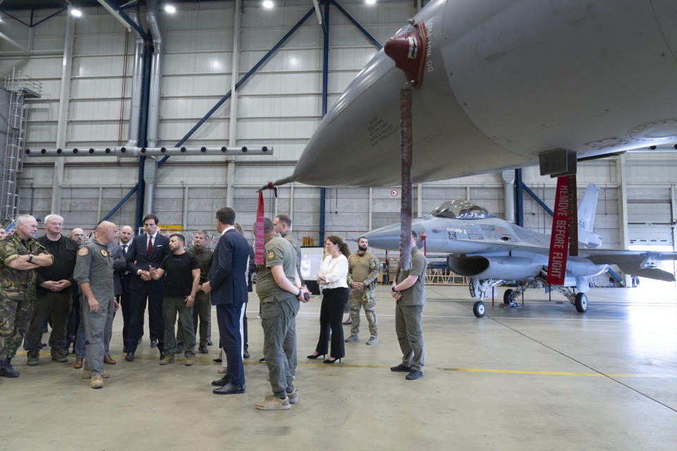 Ukrainian President Volodymyr Zelenskyy, center, and Dutch caretaker Prime Minister Mark Rutte, center right, look at F-16 fighter jets in Eindhoven, Netherlands, Sunday, Aug. 20, 2023. The leaders met at a military air base in the southern Dutch city, a day after Zelenskyy visited Sweden on his first foreign trip since attending a NATO summit in Lithuania last month. On Friday, the Netherlands and Denmark said that the United States had given its approval for the countries to deliver F-16s to Ukraine. (AP Photo/Peter Dejong)