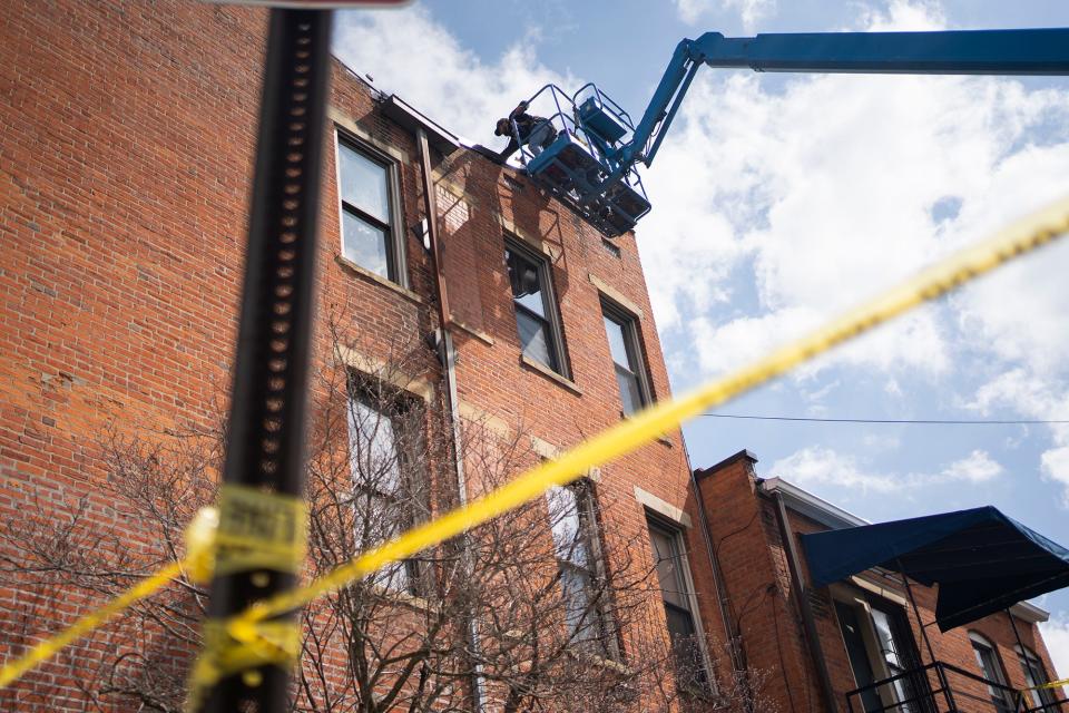 Mar 27, 2023; Columbus, Ohio, USA; Masonries remove loose bricks after high winds brought down the building's chimney and separated part of the roof from the combination commercial and residential building on the corner of Oak Street and Parsons Avenue. The building has been temporarily evacuated as a precaution.