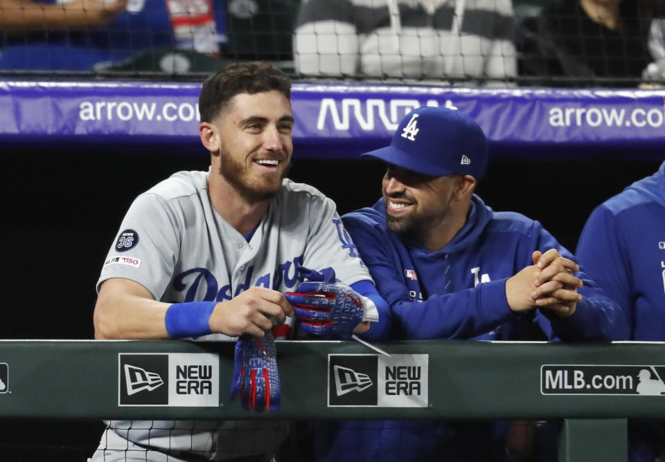 Los Angeles Dodgers' Cody Bellinger smiles as he joins a teammate on the dugout rail after hitting a solo home run off Colorado Rockies relief pitcher Bryan Shaw in the eighth inning of a baseball game Sunday, April 7, 2019, in Denver. The Dodgers went on to win 12-6. (AP Photo/David Zalubowski)