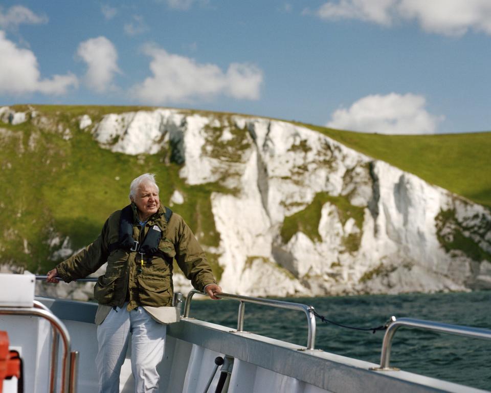 David Attenborough can be seen on board a boat while filming near White Nothe cliffs on the Jurassic Coast in Dorset, UK.