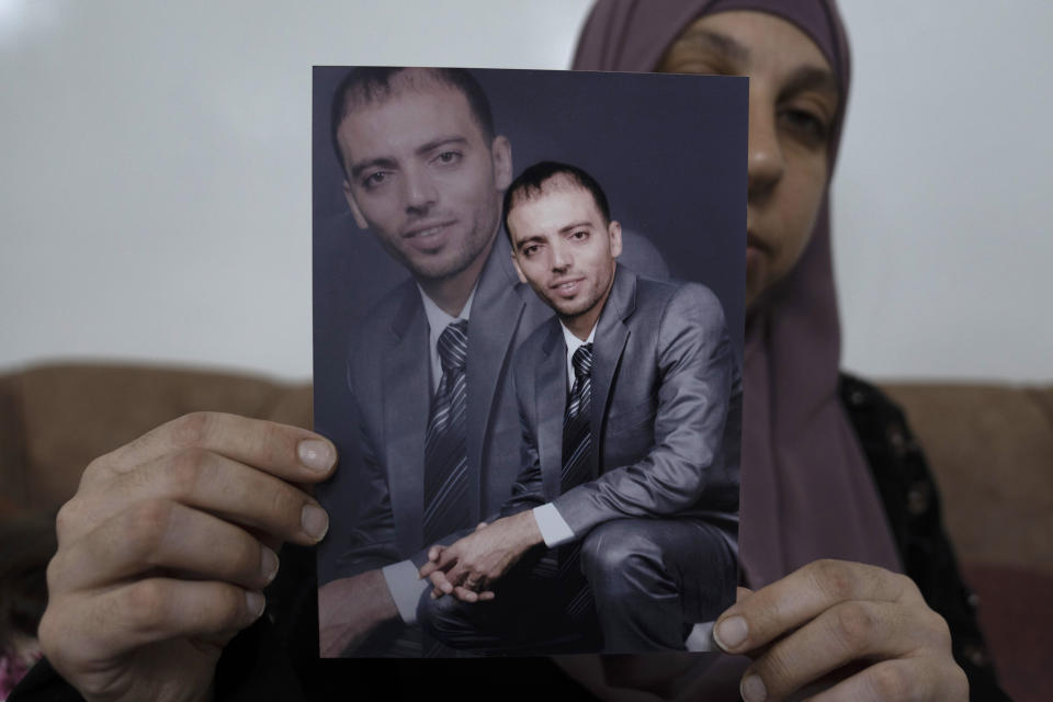 FILE - Dalal, the wife of Khalil Awawdeh, a Palestinian prisoner in Israel, displays his picture at the family house, in the West Bank town of Idna, west of Hebron, Aug. 17, 2022. Israel’s Supreme Court has rejected an appeal to release Awawdeh who has been on a hunger strike for several months to protest his detention without charge. The court rejected an appeal by his lawyer on Sunday calling for his immediate release due to his failing medical condition. Awawdeh is protesting being jailed without charge or trial under what Israel refers to as administrative detention. (AP Photo/Nasser Nasser, File)