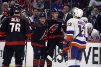 Carolina Hurricanes' Martin Necas, center right, celebrates after his empty-net goal with teammate Jack Drury, center left, and Brady Skjei (76) as New York Islanders' Mathew Barzal (13) skates by during the third period in Game 1 of an NHL hockey Stanley Cup first-round playoff series in Raleigh, N.C., Saturday, April 20, 2024. (AP Photo/Karl B DeBlaker)