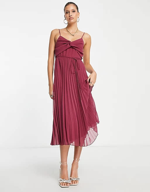 ASOS DESIGN twist front pleated cami midi dress with belt in oxblood. Image via ASOS.
