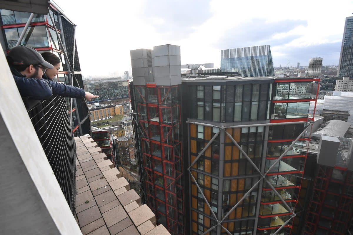 People look out from the viewing platform at Tate Modern, left, which overlooks the residential flats (PA)