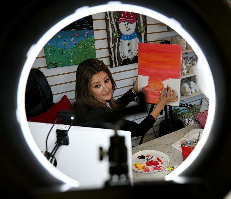 Mahsa Ghavamian, owner of Canvas n Cup in Westborough, is framed by her ring light as she teaches an an online acrylic painting class to a group of corporate customers, Nov. 19, 2021. Before the pandemic, her classes were all conducted in person.