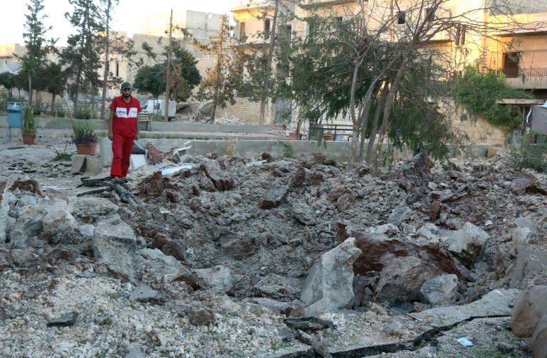 A Syrian medical staff member inspects the damage at the site of a medical facility after it was reportedly hit by Syrian regime barrel bombs