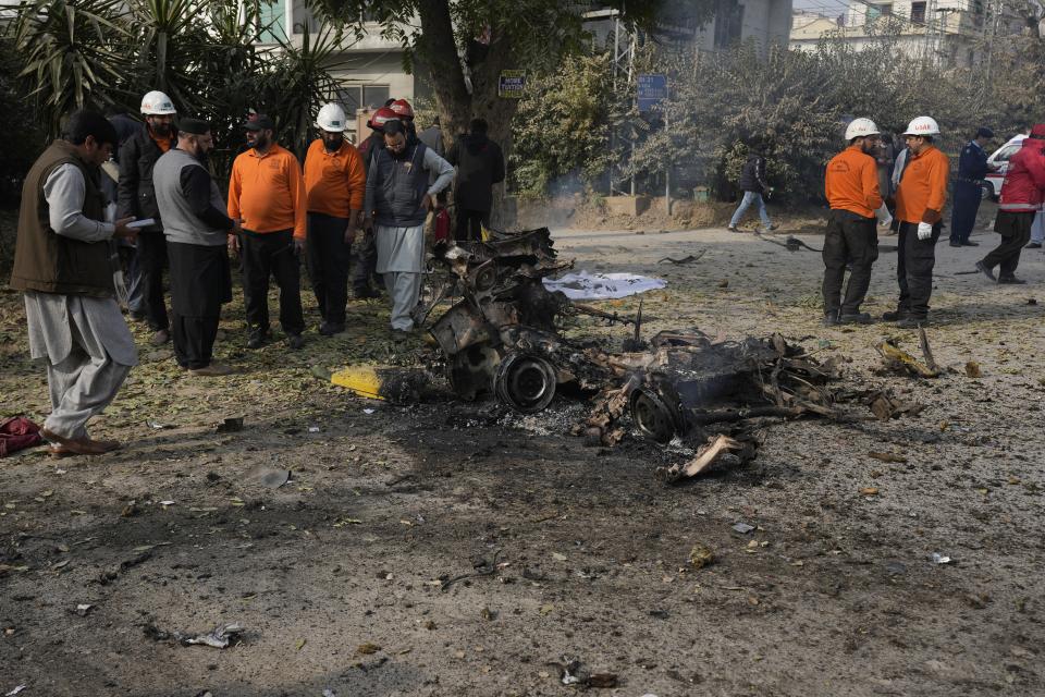 Security officials and rescue workers gather at the site of a bomb explosion, in Islamabad, Pakistan, Friday, Dec. 23, 2022. A powerful car bomb detonated near a residential area in the capital Islamabad on Friday, killing some people, police said, raising fears that militants have a presence in one of the country's safest cities. (AP Photo/Anjum Naveed)