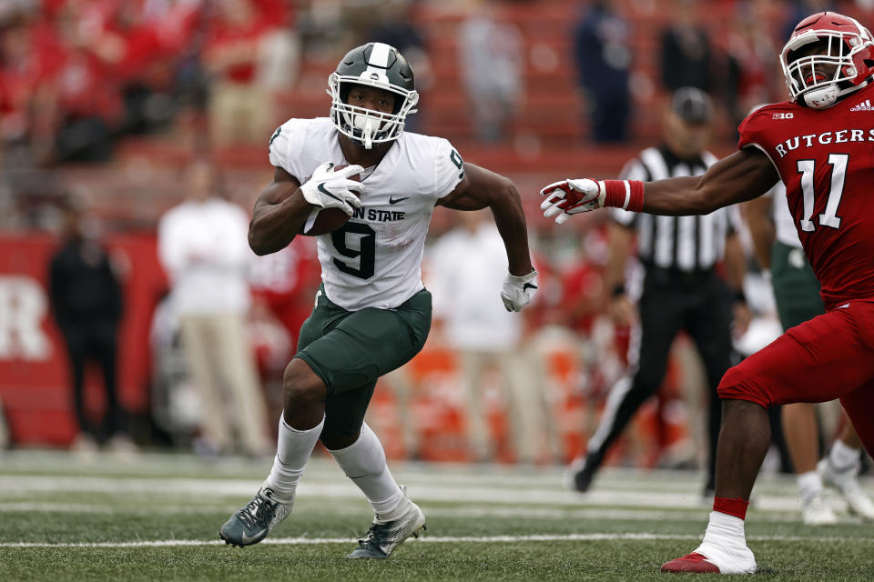 Michigan State running back Kenneth Walker III (9) runs past Rutgers linebacker Drew Singleton during the first half of an NCAA college football game Saturday, Oct. 9, 2021, in Piscataway, N.J. Michigan State won 31-13. (AP Photo/Adam Hunger)