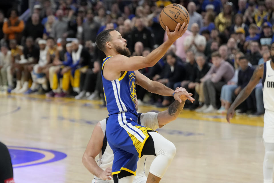 Golden State Warriors guard Stephen Curry, foreground, shoots against Dallas Mavericks guard Luka Doncic during the second half of an NBA basketball game in San Francisco, Tuesday, April 2, 2024. (AP Photo/Jeff Chiu)