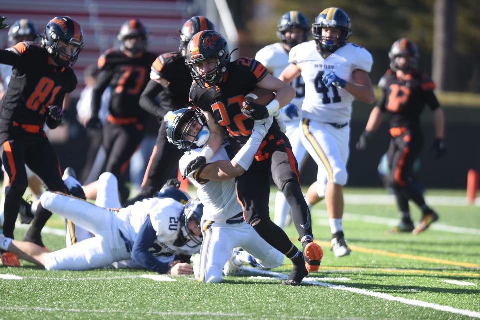 Almont's Matthew Bacholzky tries to break a tackle during a Division 6 state semifinal against Ovid-Elsie at Grand Blanc High School on Saturday.
