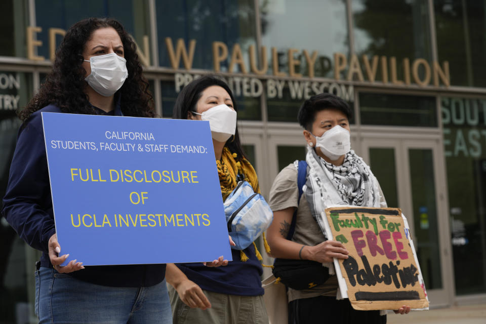 Demonstrators hold signs on the UCLA campus Wednesday, June 12, 2024, in Los Angeles. The president of the University of Miami has been chosen to become the next chancellor of the University of California, Los Angeles, where the retiring incumbent is leaving a campus roiled by protests against Israel's war in Gaza. (AP Photo/Damian Dovarganes)