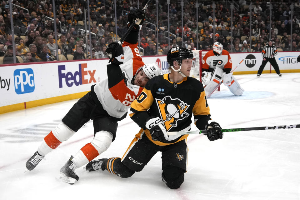 Pittsburgh Penguins' Lars Eller (20) and Philadelphia Flyers' Sean Walker (26) collide during the second period of an NHL hockey game in Pittsburgh, Sunday, Feb. 25, 2024. (AP Photo/Gene J. Puskar)