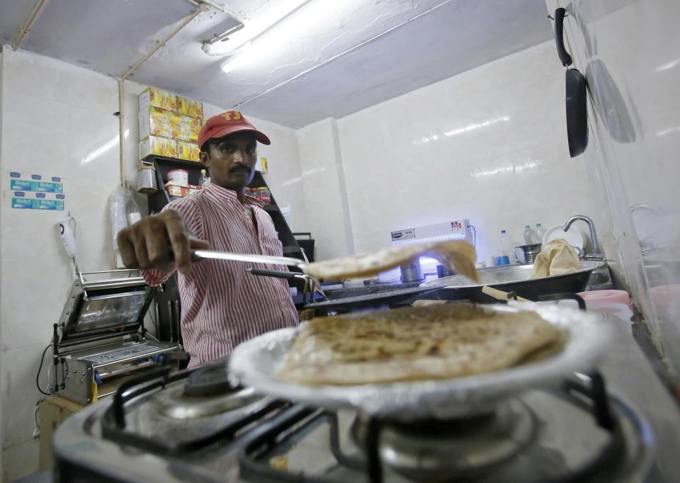 An inmate prepares food inside the kitchen of a restaurant run by the Tihar Jail authorities on Jail Road in west Delhi July 21, 2014. "Tihar Food Court" in west Delhi, a rehabilitation effort kicked off by the Tihar prison, opened in the first week of July on an "experimental basis" while awaiting formal clearances. It is sited half a km (0.6 mile) away from prisoners' dormitories. With a spacious interior lined with wooden tables and walls adorned with paintings done by prisoners, the 50-seat restaurant has been praised for the polite behaviour of its employees, who were trained by a prestigious nearby hotel management school. Picture taken July 21, 2014. REUTERS/Anindito Mukherjee (INDIA - Tags: CRIME LAW FOOD SOCIETY)