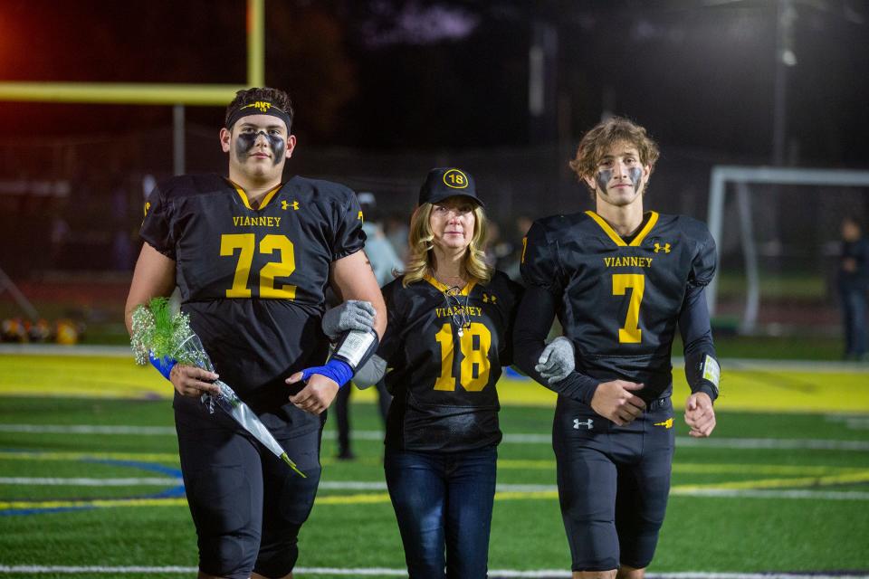 Debra Van Trease, mother of Aaron Van Trease, an SJV football senior who sustained a spinal cord injury this season, is escorted on the field for Senior NIght by Andrew Chemo and Jack Farah before the Point Pleasant Borough vs. St. John Vianney at St. John Vianney High School in Holmdel, NJ Friday, October 21, 2022. 