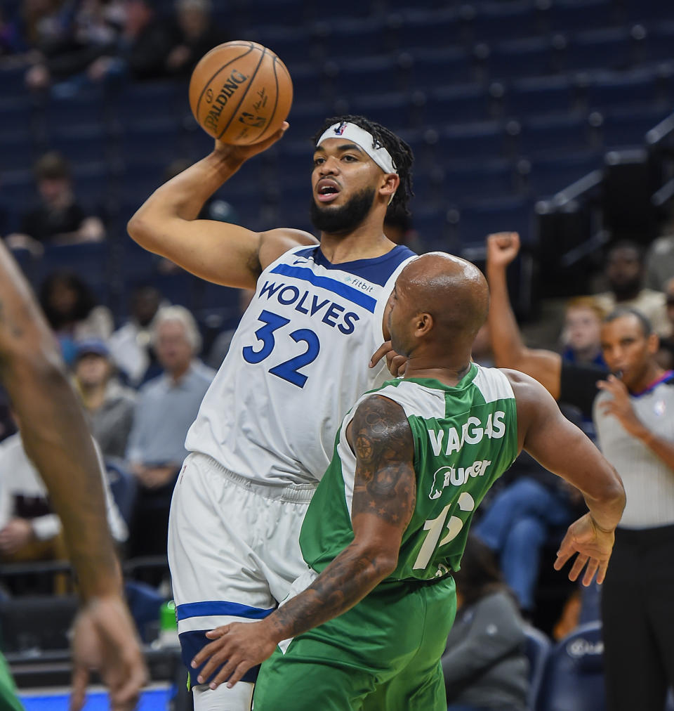 Minnesota Timberwolves center Karl-Anthony Towns tries to pass the ball as he collides with Maccabi Haifa guard Gregory Vargas during the first half of a preseason NBA basketball game Sunday, Oct. 13, 2019, in Minneapolis. (AP Photo/Craig Lassig)