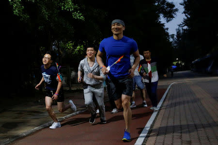 People take part in a 5.17 km run to mark International Day Against Homophobia in a park in Beijing, China, May 17, 2018. REUTERS/Thomas Peter