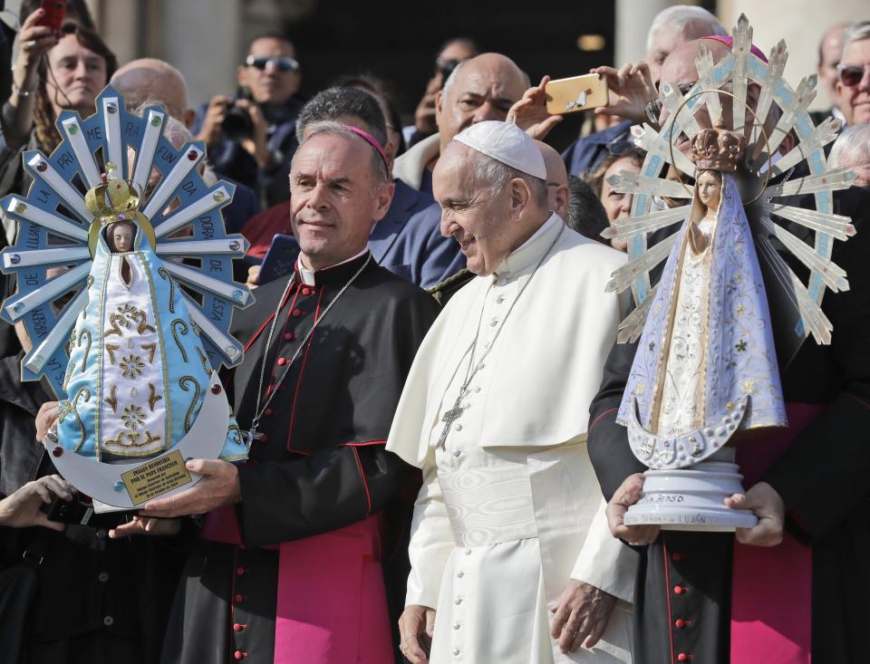 FILE - In this Oct. 30, 2019 file photo, Pope Francis poses for photographs with British Bishop Paul Mason, left, as they hold statues of Our Lady of Lujan, the original held at right, and its replica, left, at the end of his weekly general audience in St. Peter's Square, at the Vatican. Pope Francis is giving his blessing to a new Vatican think tank that is seeking to prevent the Mafia and organized crime groups from exploiting the image of the Virgin Mary for their own illicit ends. (AP Photo/Andrew Medichini)