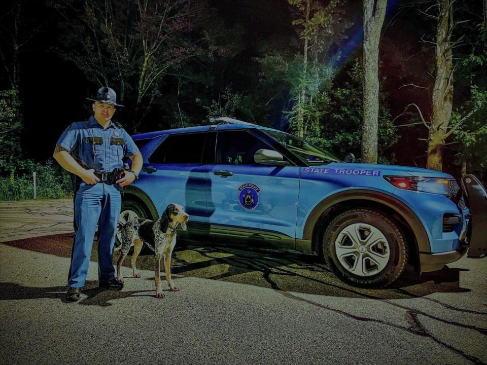Maine State Trooper Matthew Williams is seen here with Whiskey, the West Virginia hunting dog who had been missing for days, following a traffic accident on the Maine Turnpike in Ogunquit on Wednesday, Sept. 14, 2022.